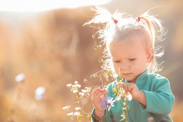 little girl playing with flowers